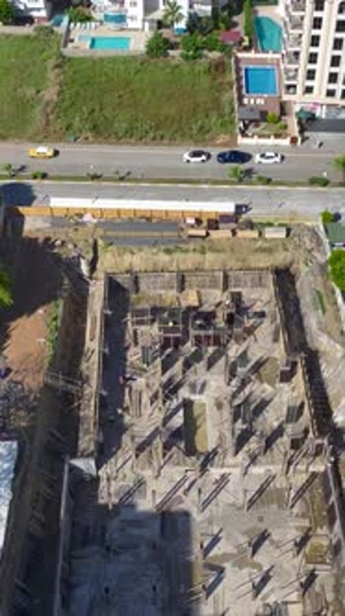 Vídeo vertical: trabajadores cualificados construyen paredes en una bulliciosa obra de construcción destacando la precisión