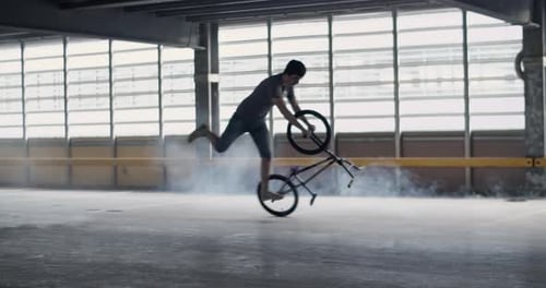 Man Performing Bike Stunts in Parking Garage