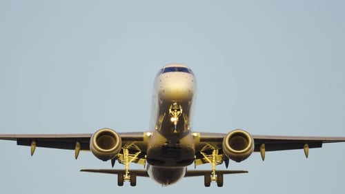 Passenger plane lands safely on runway during sunset at busy airport