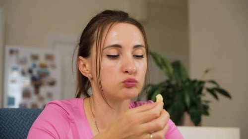 Woman eating chips in bright indoor home setting