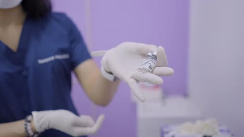 Medical Professional Holding Small Vials Indoors