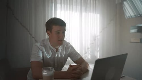 Young Adult Video Chatting on Laptop Indoors