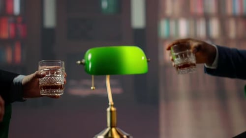 Men Clinking Glasses with Liquor in Library Setting