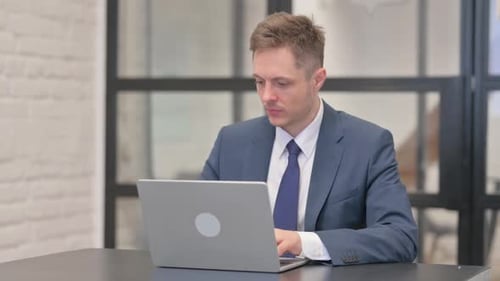 Young Businessman Working on Laptop in Office