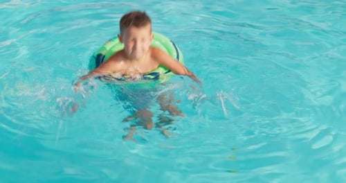 Funny Happy Child Boy in Swimming Pool on Inflatable Rubber Circle Ring