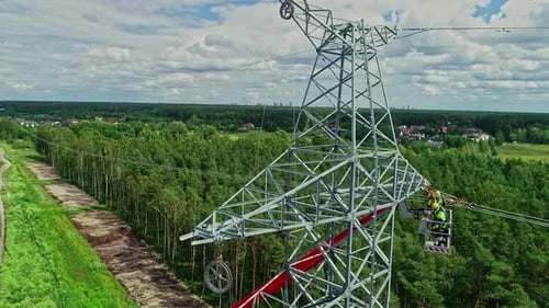 Workers Repairing Power Line Tower in Forest