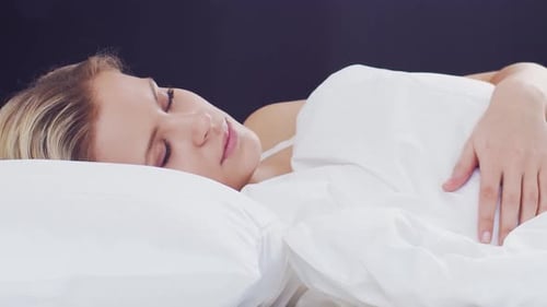Blonde Woman Sleeping Peacefully in White Bed