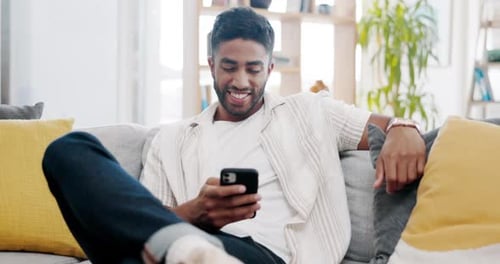 Man Relaxing on Couch Using Smartphone