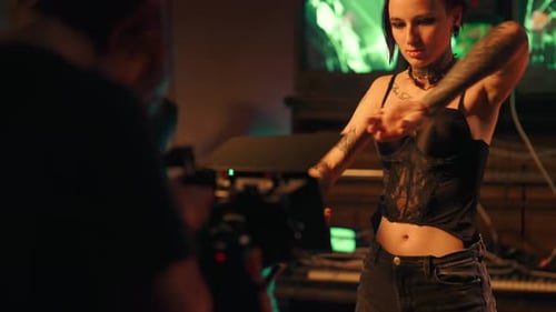 Sexy Young Woman with Tattooed Slender Body Dancing for Camera in Studio Professional Shooting of