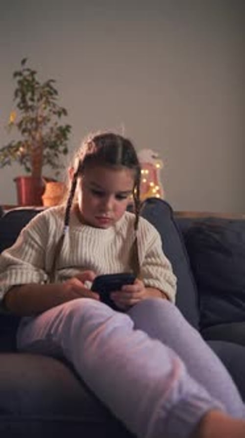 Child on Couch Uses Phone