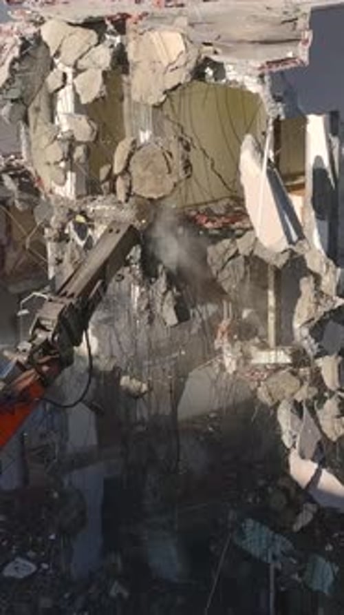 Vertical Video A Large Excavator Uses a Hydraulic Hammer to Destroy Walls and Clear an Old Site for
