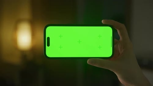 Hand Holding Smartphone with Green Screen Mockup