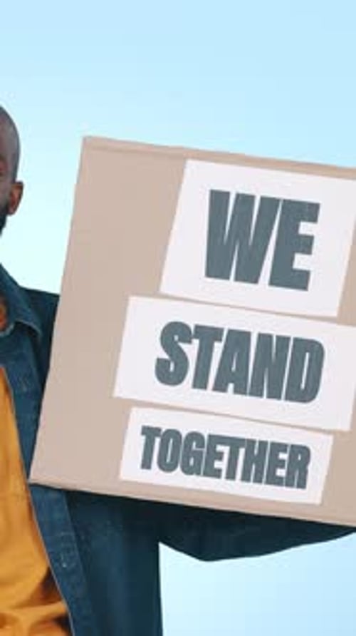 Face, unity and black man in studio, sign and poster for motivation on blue background
