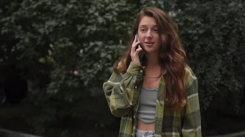 Beautiful attractive young girl woman talking on the phone while walking around the city