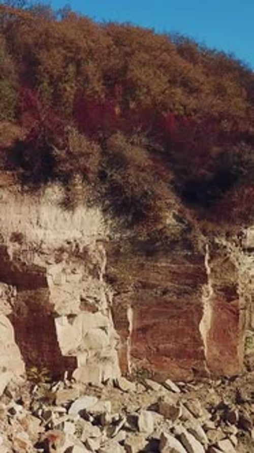 view of a large sand quarry with stones and forest.