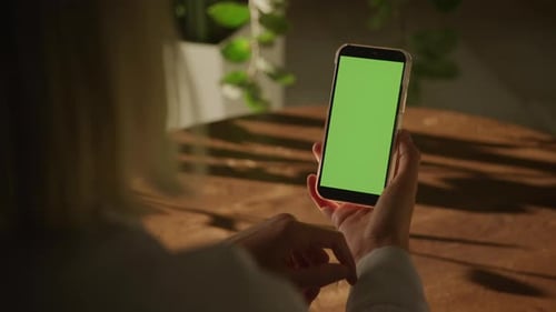 Over The Shoulder View Woman Holding Green Screen Smartphone