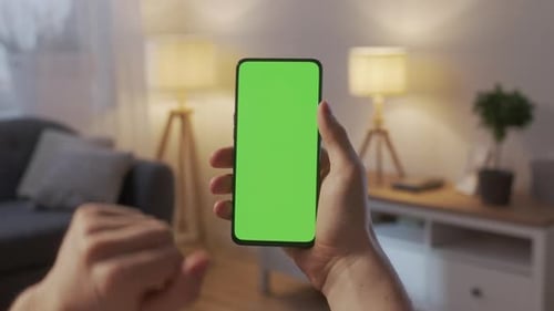 Point of View of Man at Living Room Using Phone With Green Mockup Screen Chroma Key Without Track
