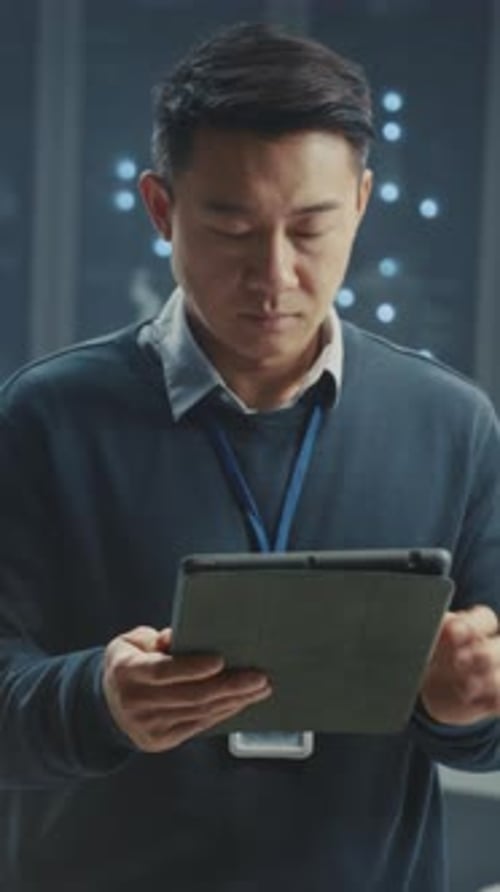 Server Technician Examining Data on Tablet in Data Center