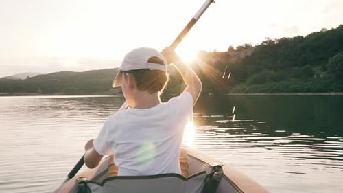 Child Kayaking on Lake at Sunset
