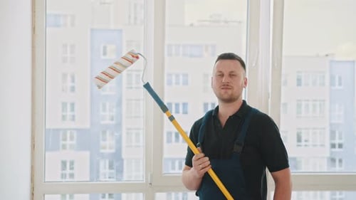 Man Holding Paint Roller in Apartment