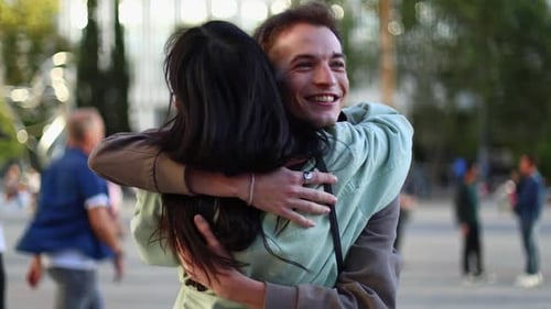 Happy Interracial Couple Spinning and Hugging in a City Park