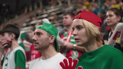 Enthusiastic Sports Fans Cheering at an Indoor Stadium