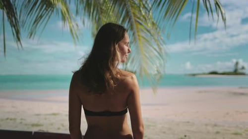 Beautiful Young Woman Standing Palm Trees is Enjoying Tropical Beach Vacation