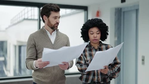Business Colleagues Collaborate on Project Details in Modern Office