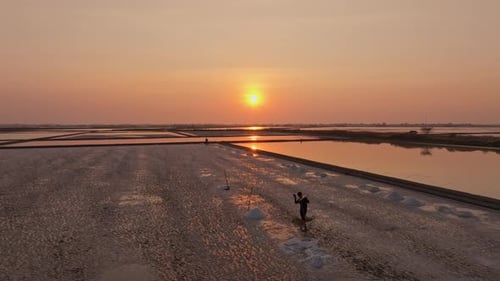 Aerial view of salt farming at sunset in Thailand's evaporation ponds