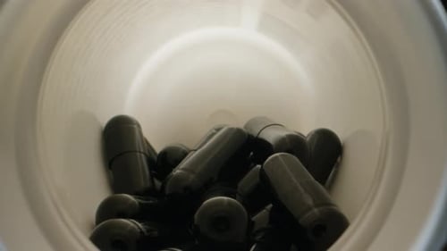 Close Up of Black Capsules Inside Bottle