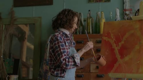 Woman Painting Picture On Easel Concentrated Artist Drawing on Canvas
