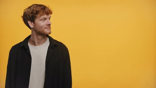 Happy Man Pointing in Both Directions on Yellow Background