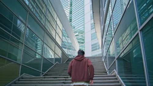 Man Running Urban Stairs Between Glass Buildings Fit Runner Training in City