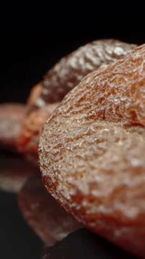 Dried apricots on a black background and mirror image. Dolly zoom. close upVertical video.