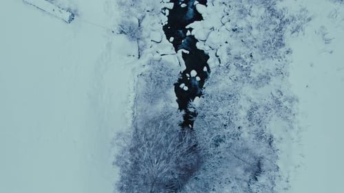 Aerial Drone Shot of Snow Covered River in Forest