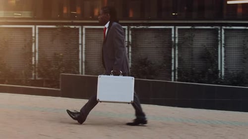 Man Walks with Briefcase in Golden Hour