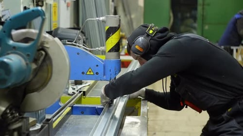 A Man in a Special Suit Looks Carefully at the Work Done on the Metal