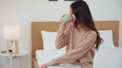 Happy Woman Enjoying Coffee in Bed at Home