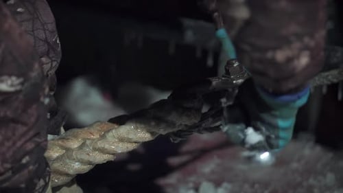 Close up of worker fastening rope with metal tool. Clip. Using wrench for works at the construction