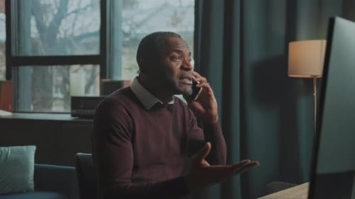 Upset Man Arguing on Phone in Home Office