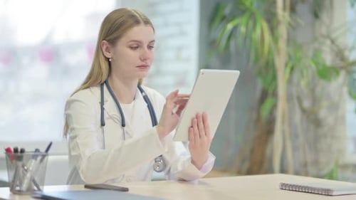 Young Doctor Browsing Tablet in Clinic