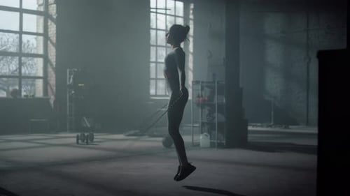 Fit Girl Jumping Skipping Rope in Dark Gym. Body Silhouette Sport Woman