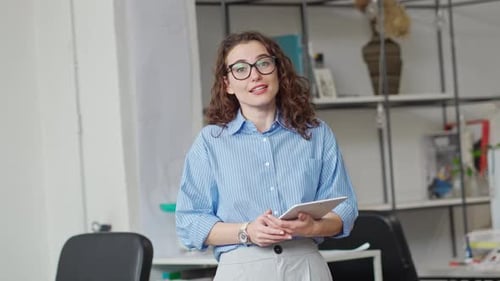Young Woman Presenting Information in Office with Tablet