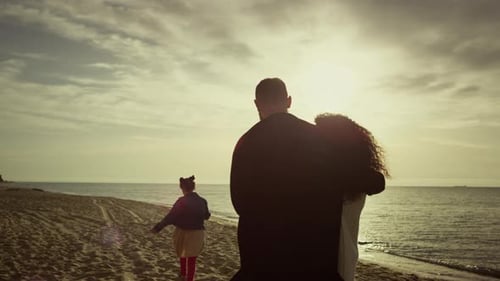 Lovely Family Looking Sunset Ocean Beach. Mom Dad Child Walking Beautiful Coast