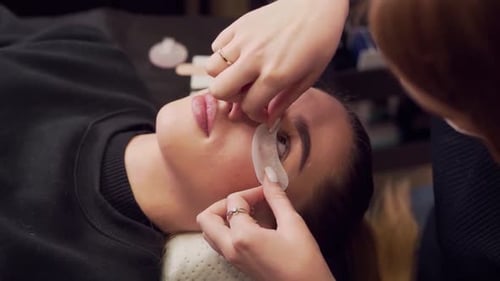 Woman Getting Eye Pads Applied Lying Down