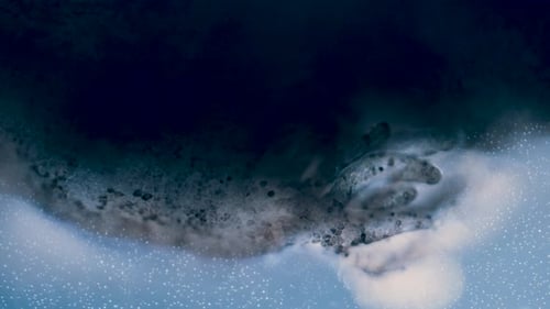 Abstract Macro Shot of Dark Swirling Liquid and Iridescent Bubbles