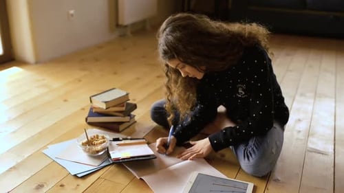 Young Woman Studying and Writing on the Floor