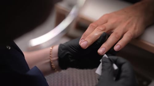 Beautician in Black Gloves Giving Manicure Treatment to Male Customer Closeup of Professional Nail