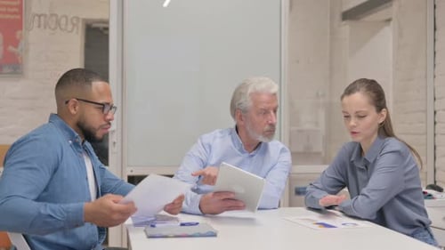 Business People Discussing Project on Digital Tablet in Office