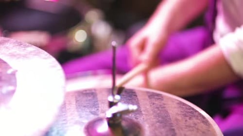 Hands Playing Drum Kit Under Purple Stage Lights